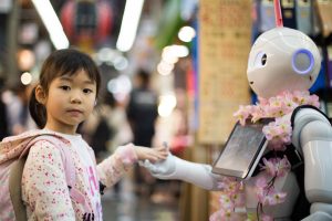 Ein kleines Mädchen hält die Hand eines Roboters
