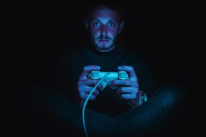 Ein Mann mit einem Controller in der Hand spielt ein Videospiel.