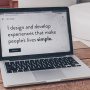 Aufgeklappter Laptop auf einem Holztisch zeigt den Satz "I design and develop experiences that make people´s lives simple."