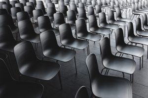 Schwarzweiß Foto von leeren Stuhlreihen.