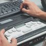 Eine blinder Mann verwendet einen Braille-Bildschirmleser